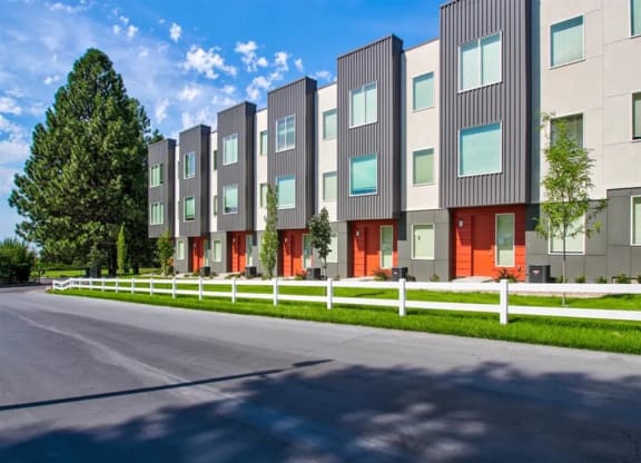 a row of houses with red doors and white fences  at Aero Luxury Townhomes in Layton, Utah