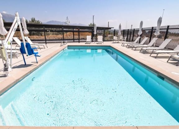 a swimming pool with chairs and umbrellas