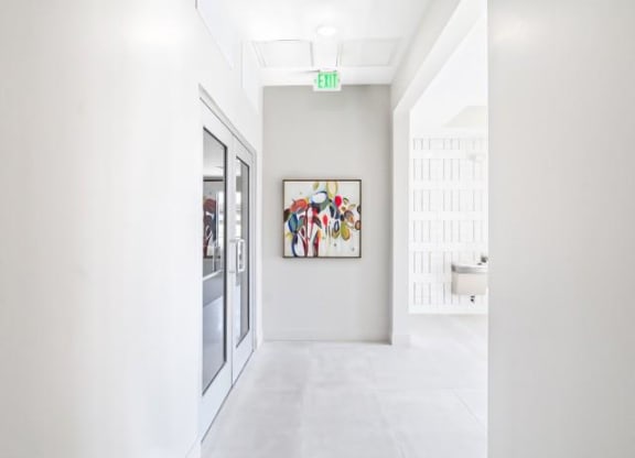 a white hallway with a painting on the wall