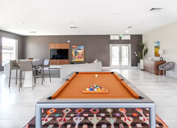 a living room with a pool table  and a dining room