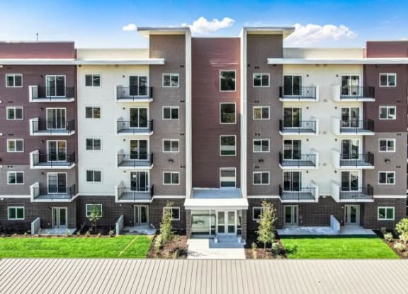 Exterior view of Lehi Tech Apartments in Lehi, UT, showcasing modern architecture, landscaped grounds, and a welcoming residential community