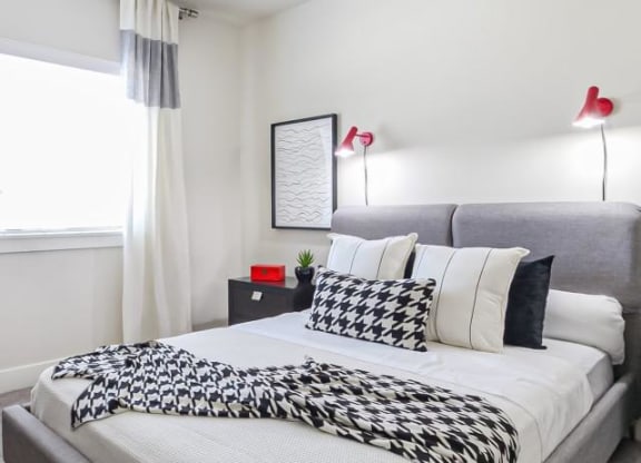 a bedroom with a bed with black and white pillows