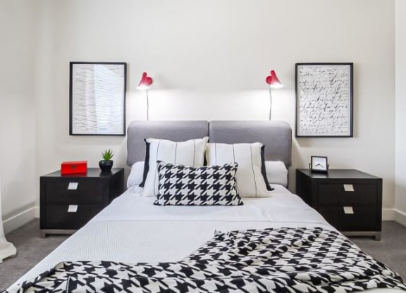 a black and white bedroom with a bed and two lamps