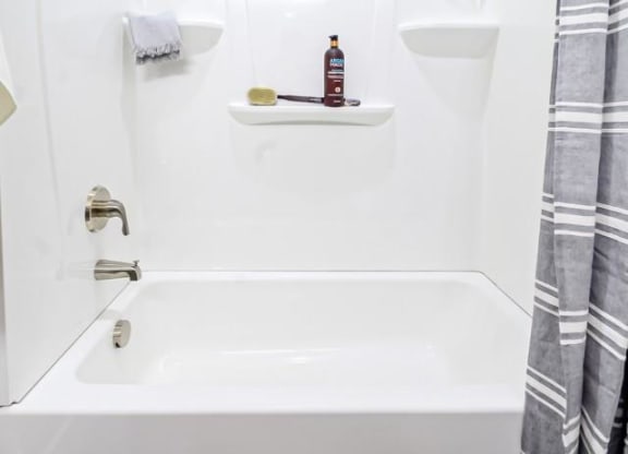 a bathroom with a white tub and a shower curtain