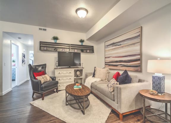 a living room with a couch and a tv at Aderra apartment complex in Roy, Utah