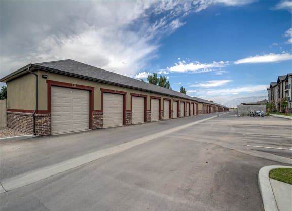 a long row of garage doors on the side of a storage building at Aderra apartments in Roy, Utah