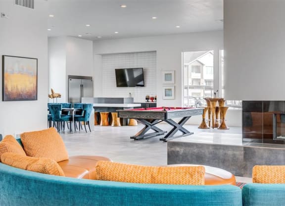 a living room with a ping pong table and a fireplace  at Affinity 56 Apartments in West Jordan, Utah