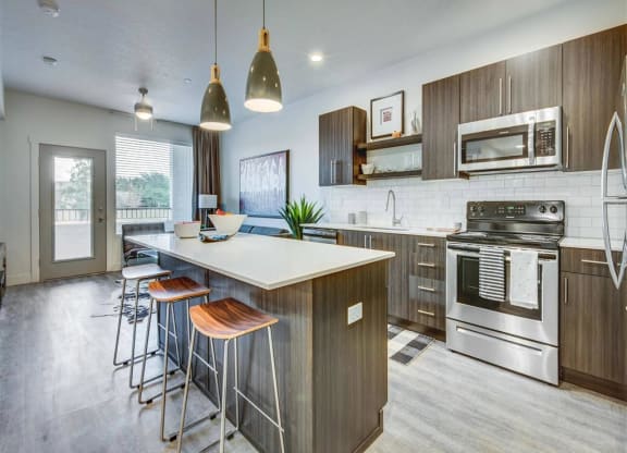 a kitchen with a large island with stools  at Affinity 56 Apartments in West Jordan, Utah