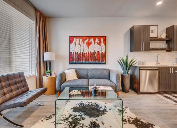 a living room with a couch and a glass table  at Affinity 56 Apartments in West Jordan, Utah