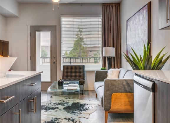 a living room with a couch and a glass table  at Affinity 56 Apartments in West Jordan, Utah