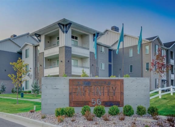 an apartment building with a sign in front of it at Affinity 56 Apartments in West Jordan, Utah
