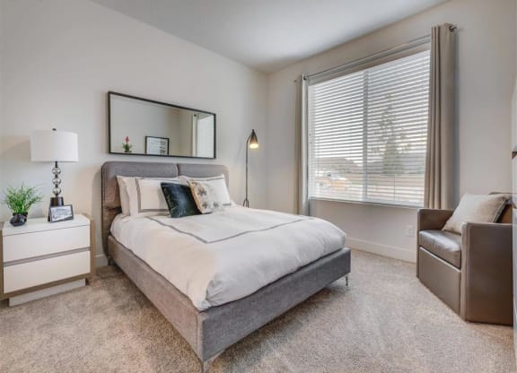 a bedroom with a bed and a window  at Affinity 56 Apartments in West Jordan, Utah