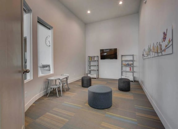 a room with a table and chairs and a clock on the wall  at Affinity 56 Apartments in West Jordan, Utah