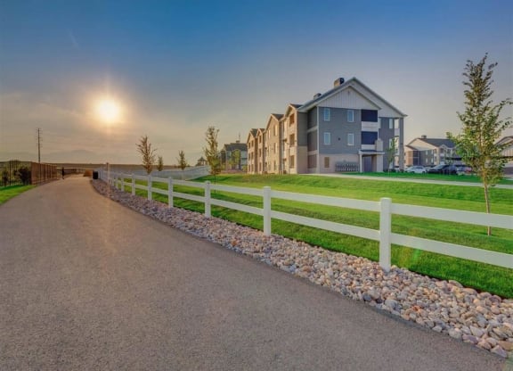 a road leading to a house with a white fence  at Affinity 56 Apartments in West Jordan, Utah