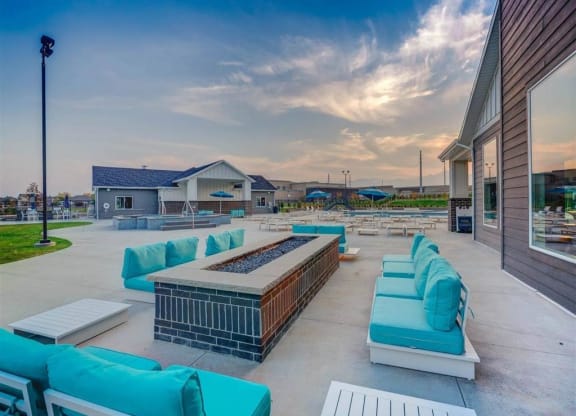 a lounge area with blue couches and chairs outside of a building  at Affinity 56 Apartments in West Jordan, Utah