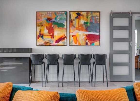 a dining room with chairs and paintings on the wall  at Affinity 56 Apartments in West Jordan, Utah