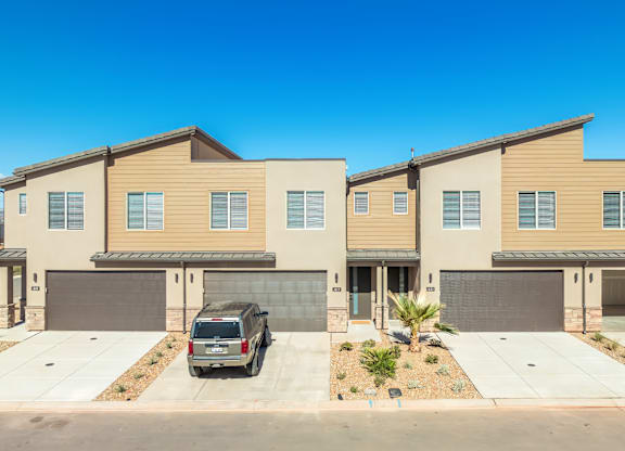 A row of modern houses with garages and driveways.