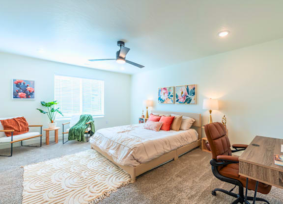 A bedroom with a bed, desk, and chair.