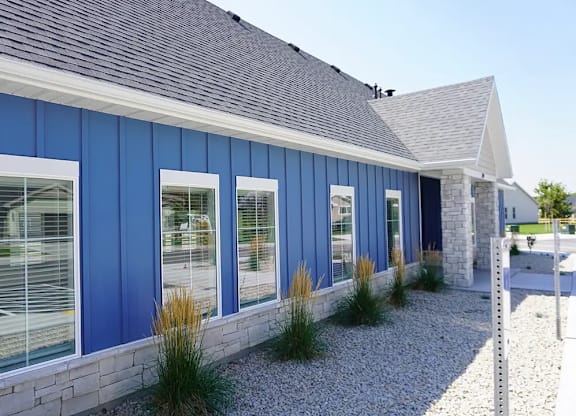 A blue building with white trim and a grey roof.