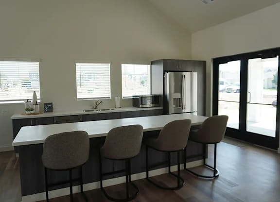 A kitchen with a bar area and four chairs.