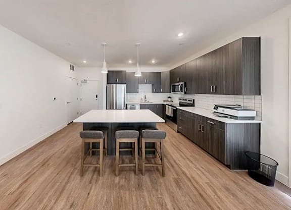 A kitchen with a table and chairs in the middle of the room.