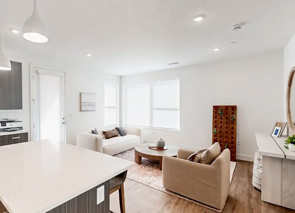 A modern living room with a white kitchen island and a white sofa.