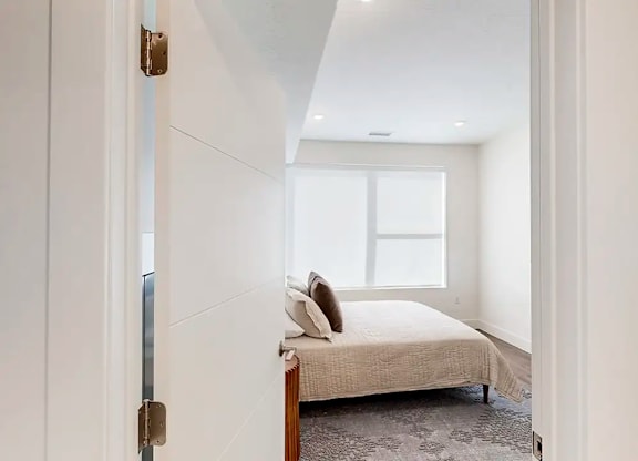 A bedroom with a bed and a window.