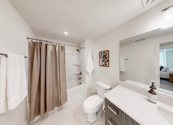 A bathroom with a toilet, sink, and shower.