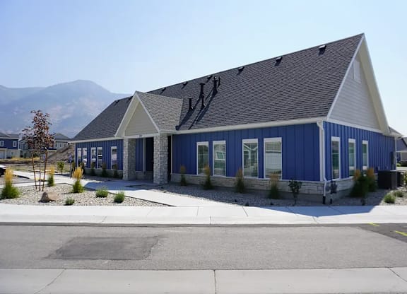 A blue and white building with a mountain in the background.