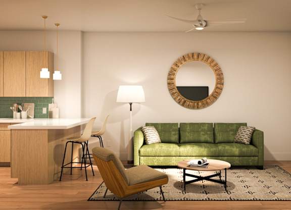 A living room with a green couch and a round mirror on the wall.