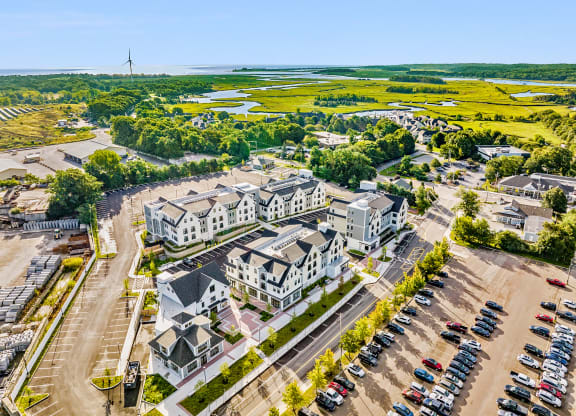 an aerial view of houses and cars in a parking lot