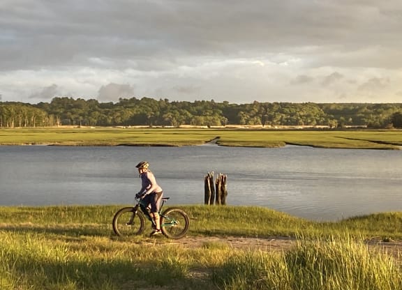 a man riding a bike next to a body of water