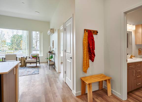 A room with a bench and a coat rack.
