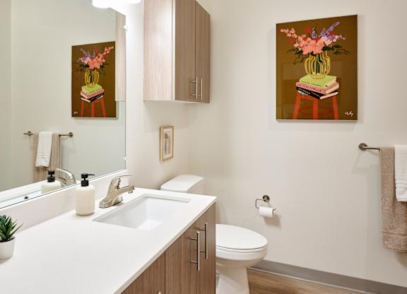 A bathroom with a white counter top and a toilet.