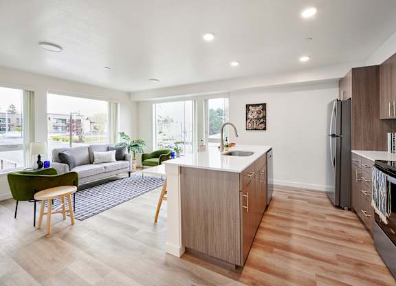 A modern kitchen with wooden floors and appliances.