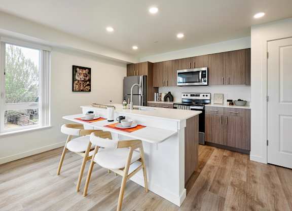 A kitchen with a white table and chairs.