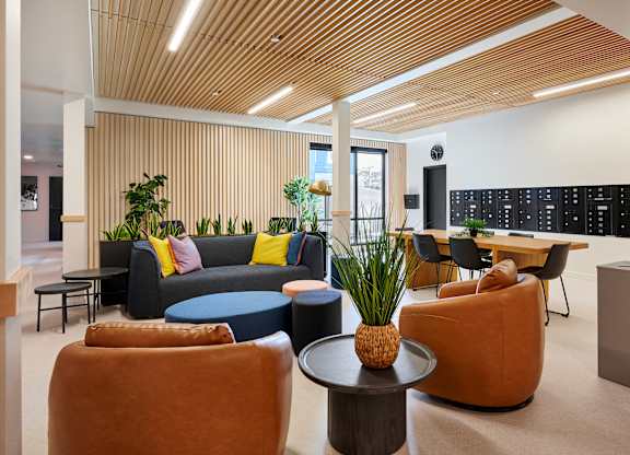 A modern living room with a wooden ceiling and a variety of seating options.