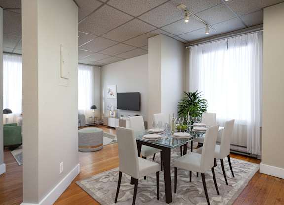 A dining room with a glass table and chairs.