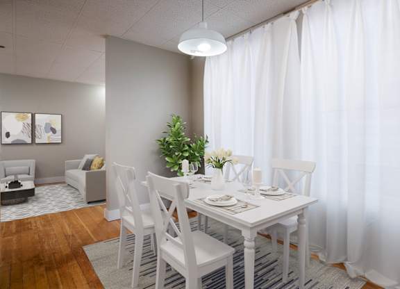 A dining room with a white table and chairs.