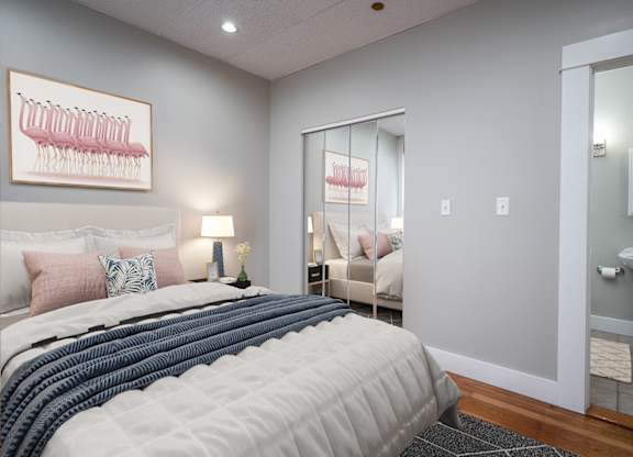 A bedroom with a large bed and a framed picture of a menorah on the wall.