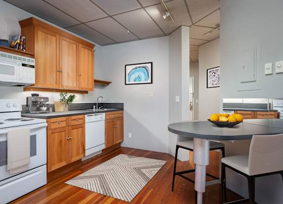 A kitchen with a table and chairs.
