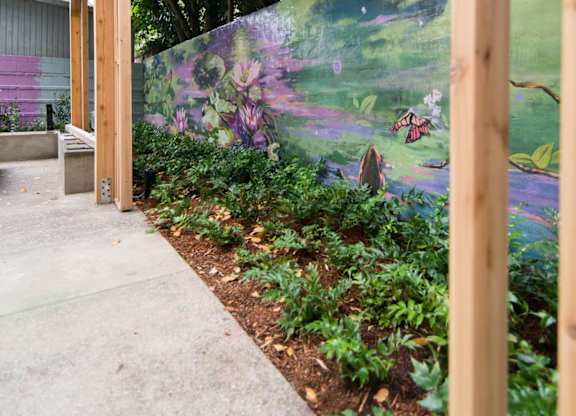 A mural of a garden scene is displayed on a wall.