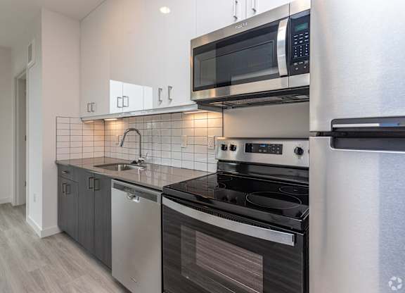A modern kitchen with a stainless steel dishwasher and oven.