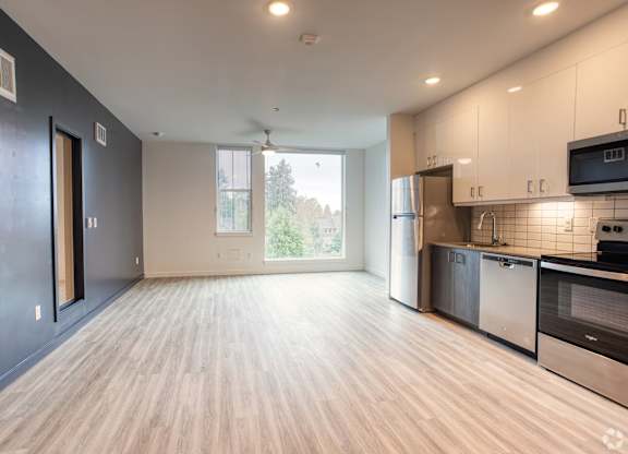A kitchen with a refrigerator, oven, and microwave.
