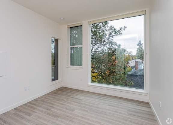 A room with a large window and a wooden floor.