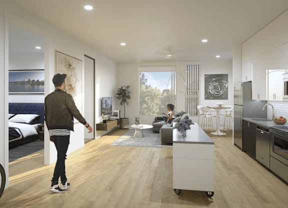 A man is walking through a modern kitchen and living room.