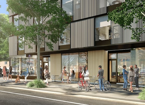 A modern building with a glass facade and people walking outside.