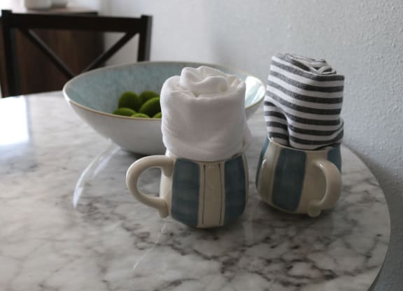 two coffee mugs with towels and a bowl of fruit on a table at Schaefer Ridge Apartments, Missouri, 65616