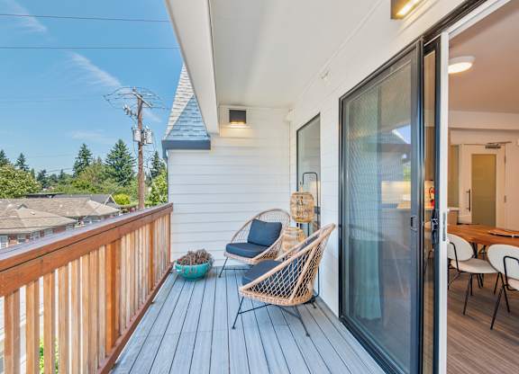 A wooden deck with a chair and a table at Society 62 Apartments, Portland