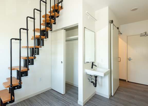 A white bathroom with a black metal staircase at Society 62 Apartments, Portland, Oregon